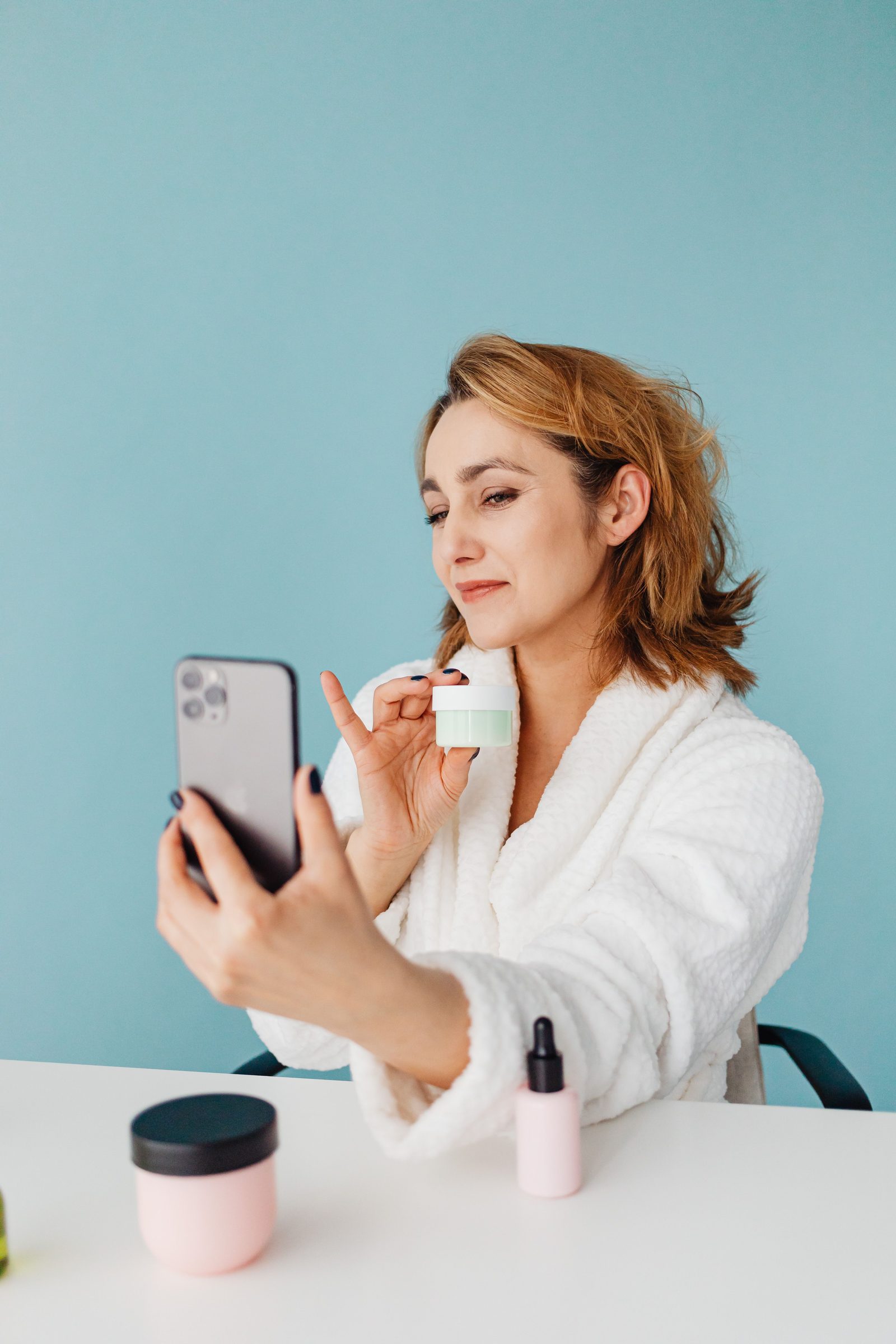 Woman holding a skincare jar in a bright modern setting