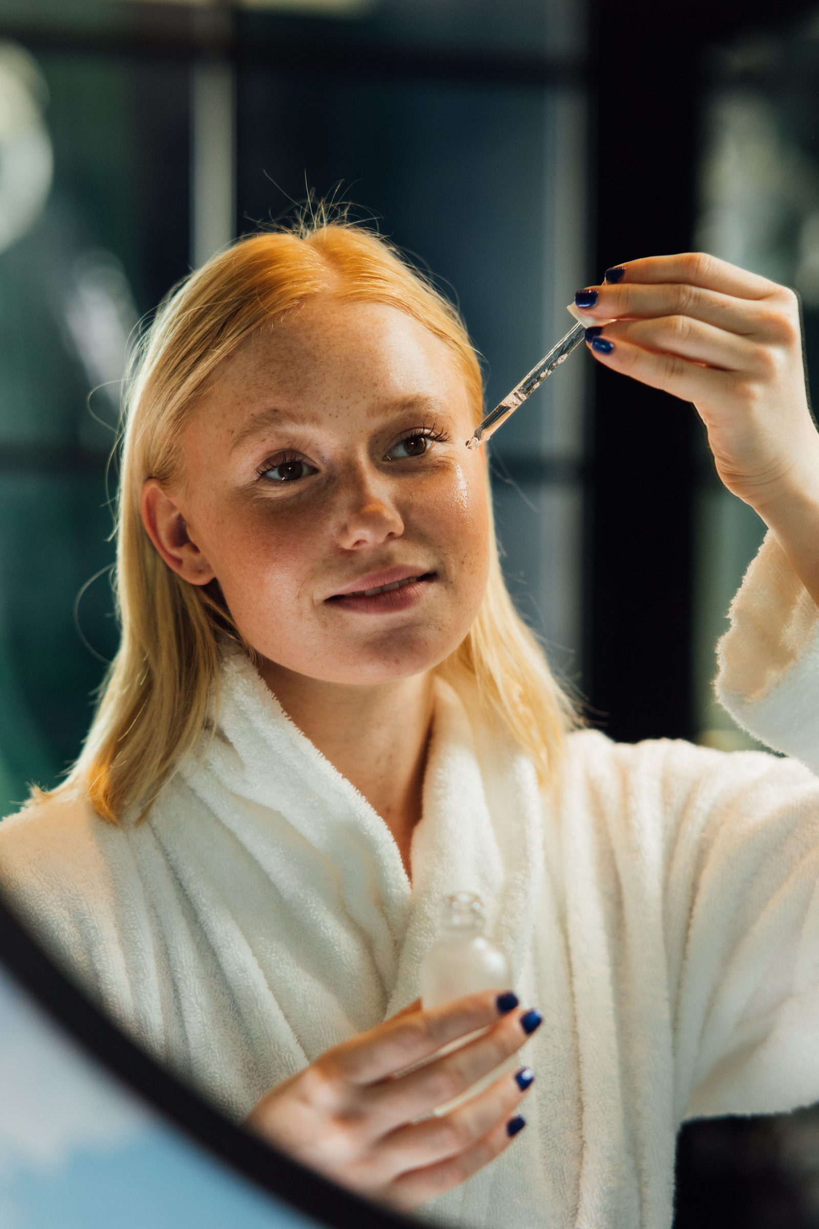 Woman using facial serum as part of a skincare ritual