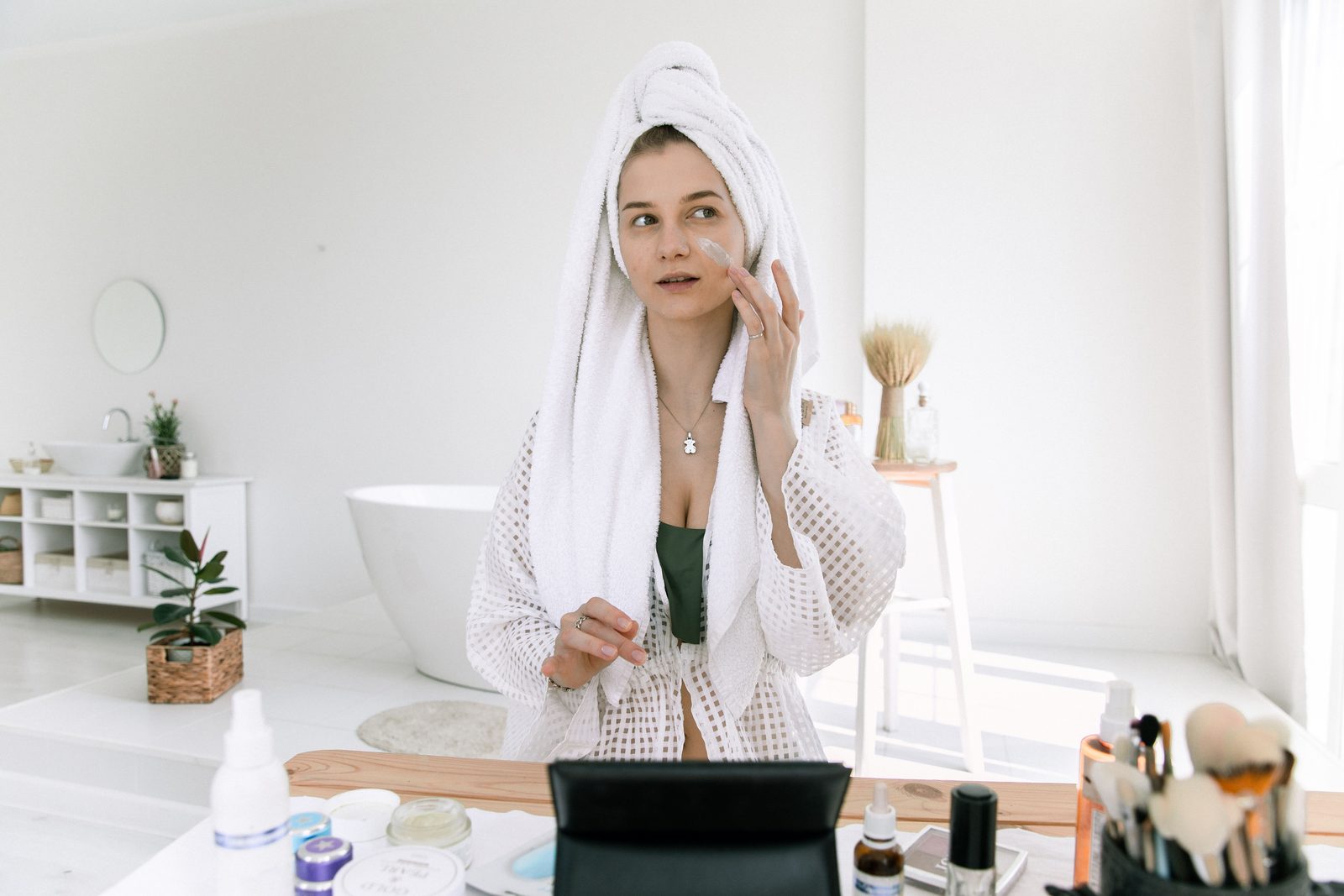 Woman enjoying a clean skincare ritual in a bright bathroom